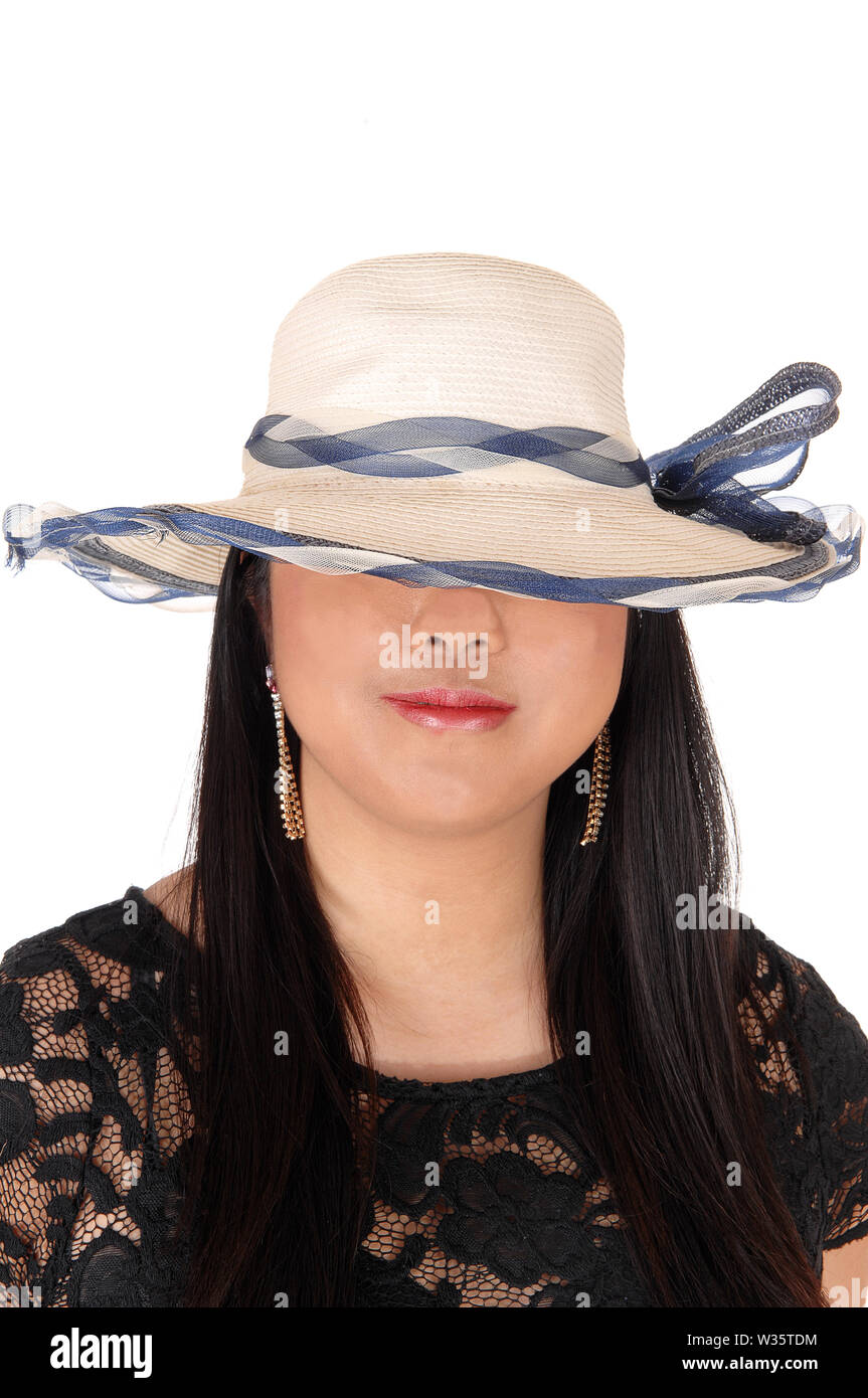 A beautiful young Chinese woman in a black dress and summer hat over her eye's looking mysterious, isolated for white background Stock Photo