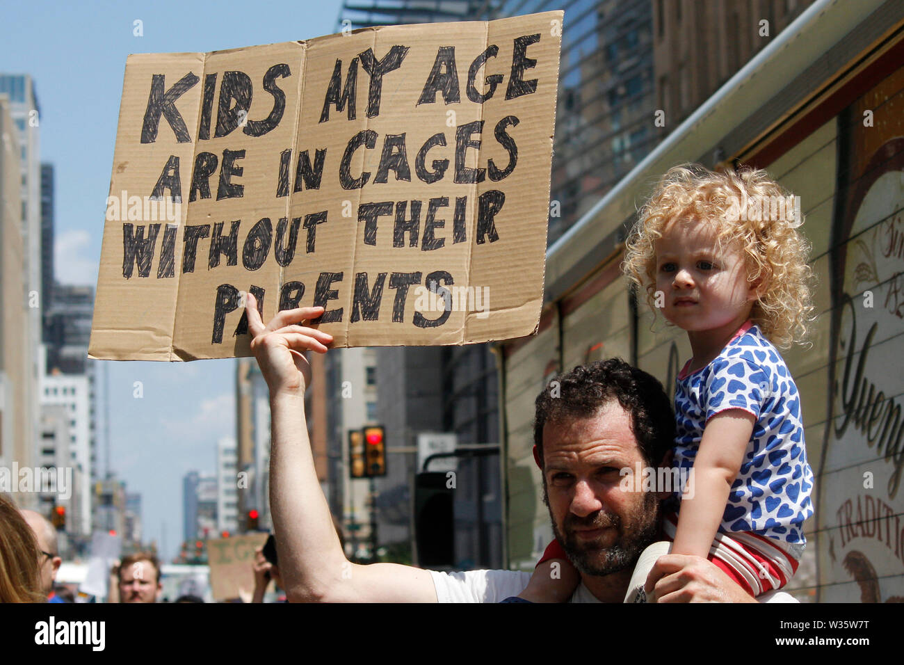 Philadelphia, PA, USA - July 12, 2019: A father and child hold a sign  to protest inhumane conditions for children in immigration detention camps. Stock Photo
