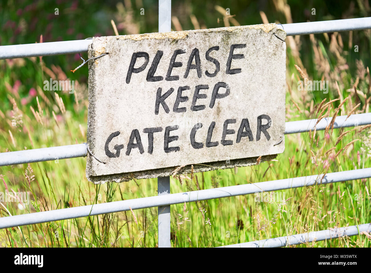 Please keep gate clear sign in metal gate fence Stock Photo Alamy
