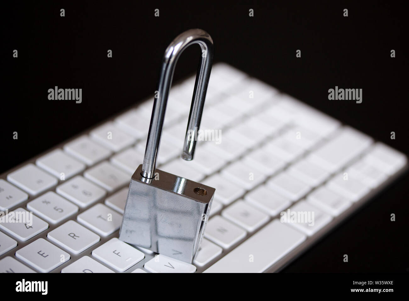 Stainless padlock on computer keyboard. PC network security, data security and antivirus protection concept. - Image Stock Photo