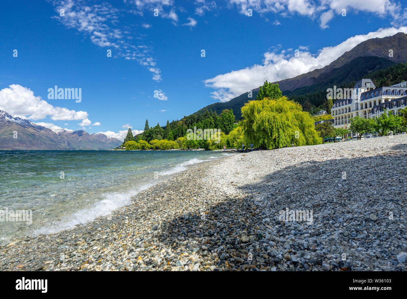 Stoney shoreline of Lake Wakatipu with mountains in background, Queenstown, South Island New Zealand Stock Photo