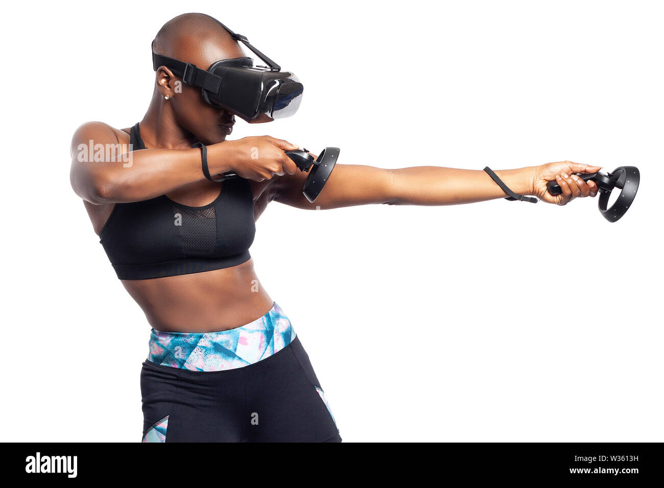 Athletic black female playing a first person shooter video game in VR with  a virtual reality headset and controllers. She is pretending to shoot a gun  Stock Photo - Alamy