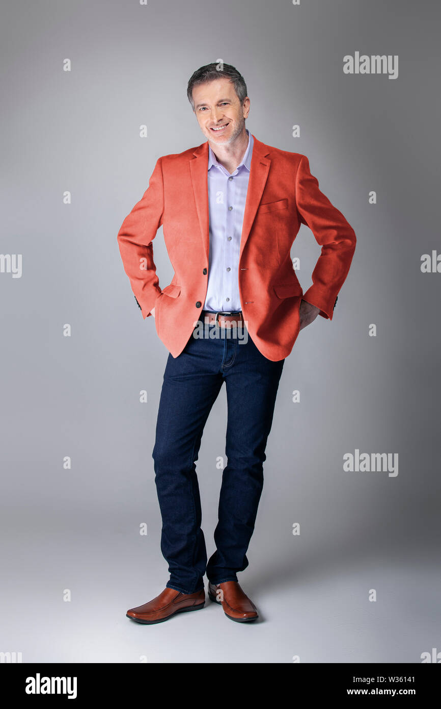 Middle aged fashion model wearing coral colored sports coat or jacket for the fall clothing collection. Depicts modern colorful apparel style for 201 Stock Photo Alamy