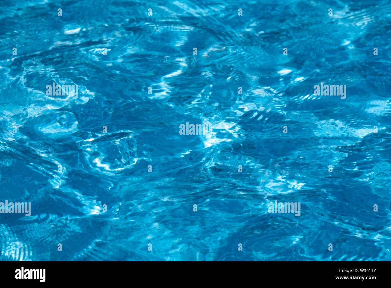 Blue and bright ripple clean water surface in swimming pool with sun ...