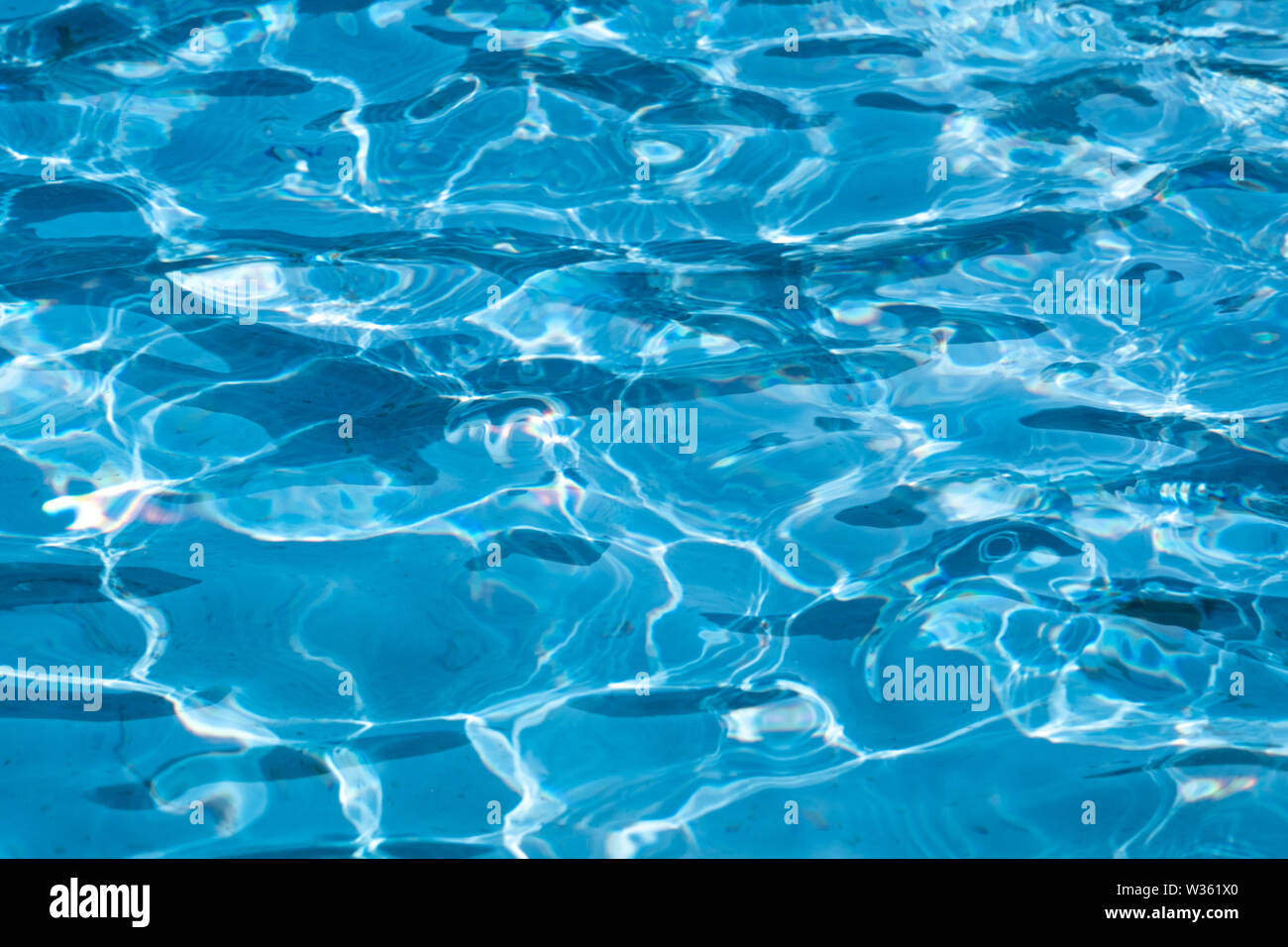 Blue and bright ripple clean water surface in swimming pool with sun ...