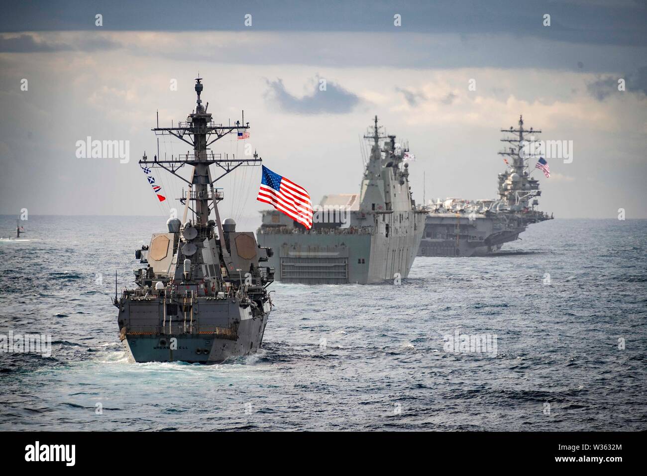 190711-N-WI365-1052 TASMAN SEA (July 11, 2019) – The amphibious dock landing ship USS Ashland (LSD 48) sails in formation behind the Arleigh Burke-class guided-missile destroyer USS McCampbell (DDG 85), center, the Royal Australian Navy Canberra-class landing helicopter dock HMAS Canberra (L02), left, the U.S. Navy Los Angeles-class submarine attack USS Key West (SSN 722), far left, and the U.S. Navy’s Nimitz-class aircraft carrier USS Ronald Reagan (CVN 76), during Talisman Sabre 2019. Ashland, part of the Wasp Amphibious Ready Group, with embarked 31st Marine Expeditionary Unit, is currently Stock Photo
