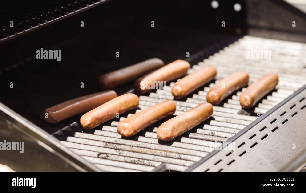 Grilling hot dogs and fresh corn on the outdoor gas grill at July 4th