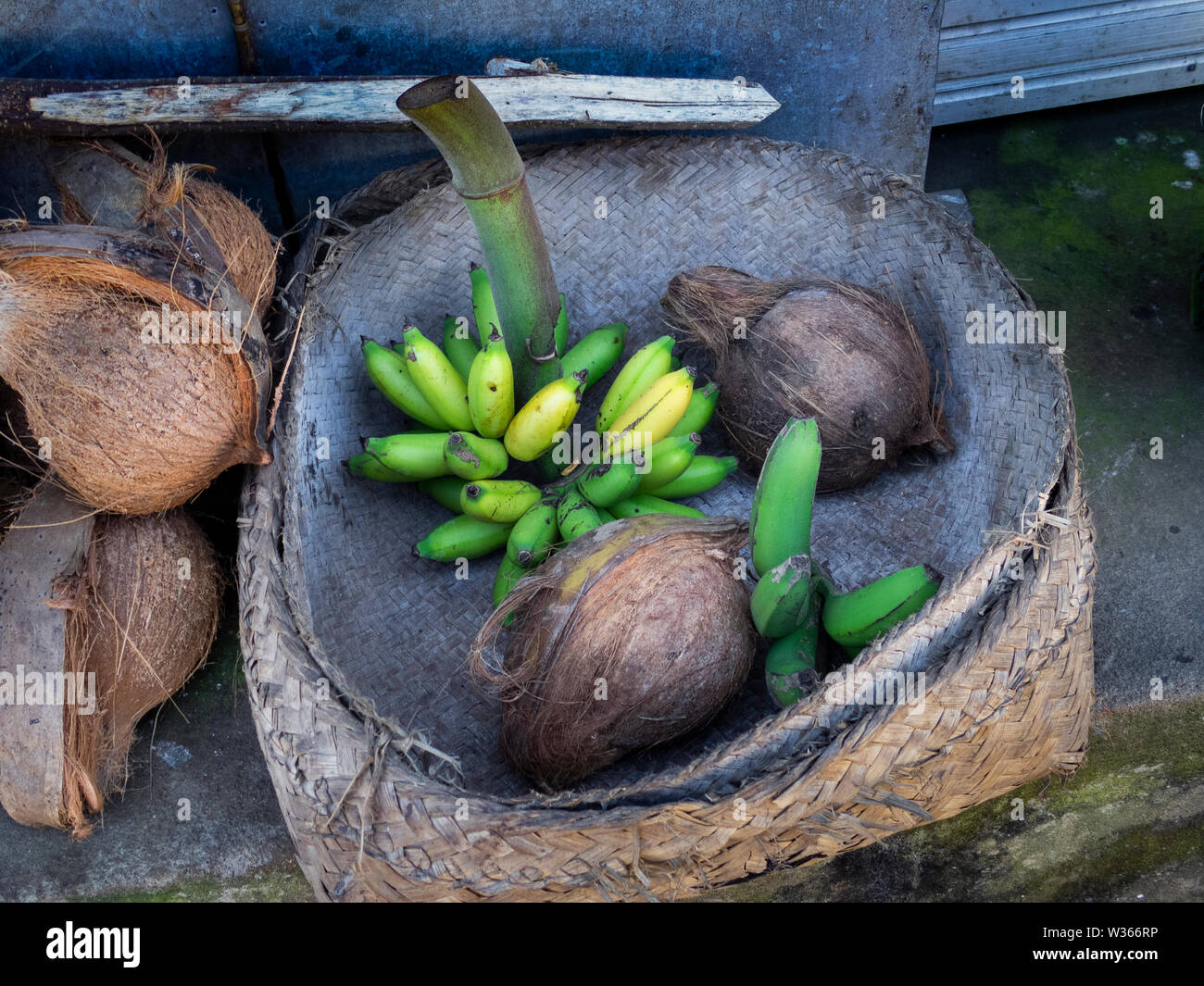 banana and coconut in a traditional handmade basket on an asian farmers market Stock Photo