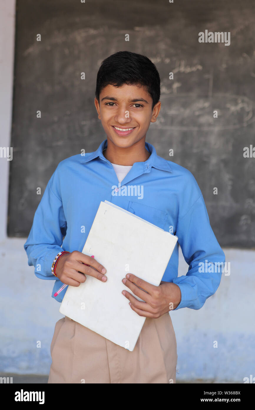 Portrait of a schoolboy holding book and smiling Stock Photo - Alamy