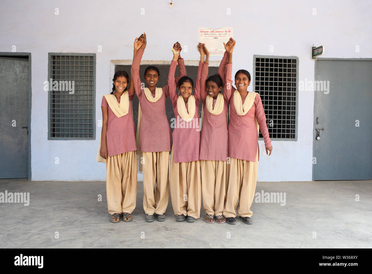 Schoolgirls smiling with their arms raised in a school Stock Photo - Alamy