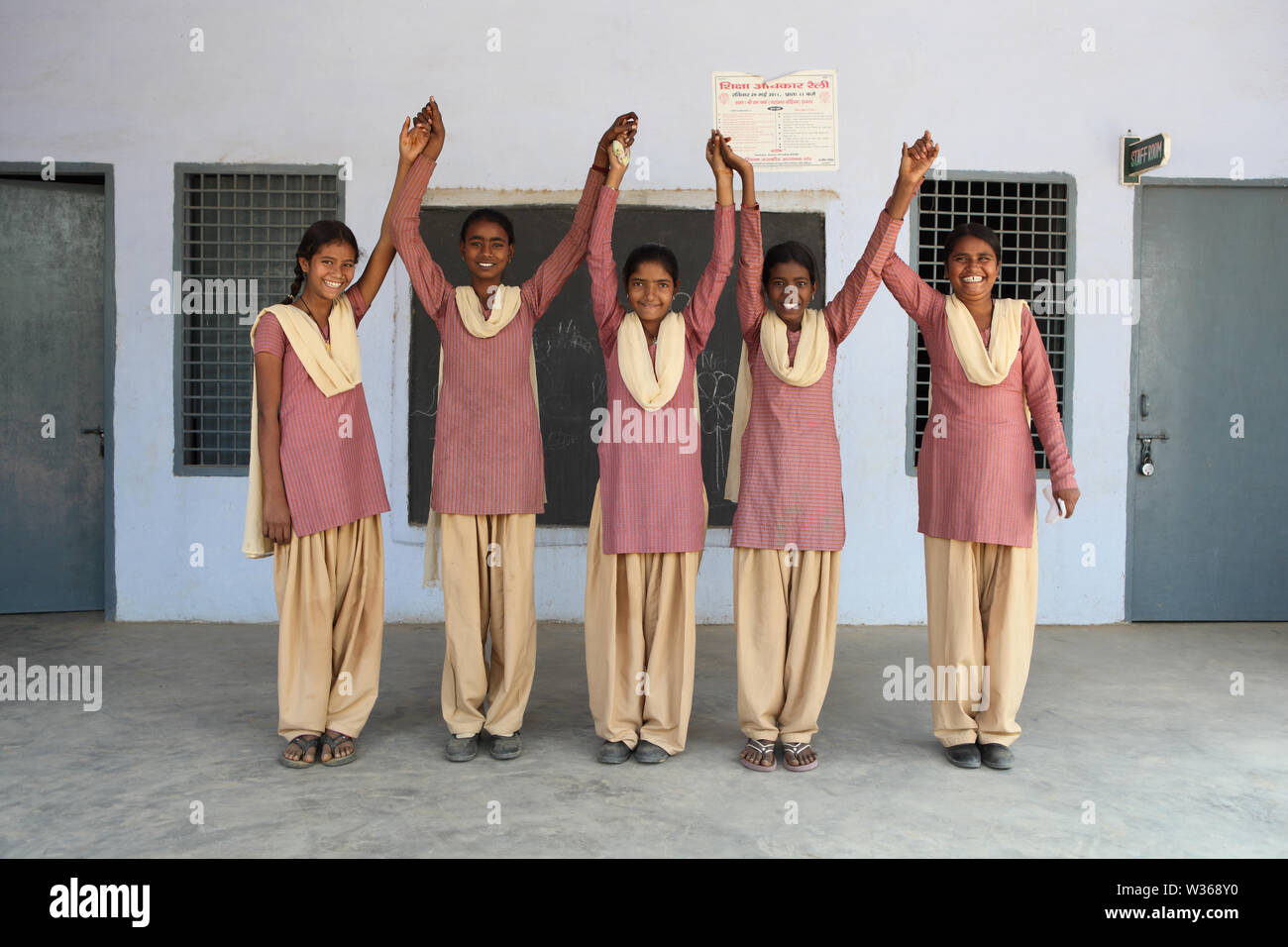 Schoolgirls smiling with their arms raised in a school Stock Photo - Alamy
