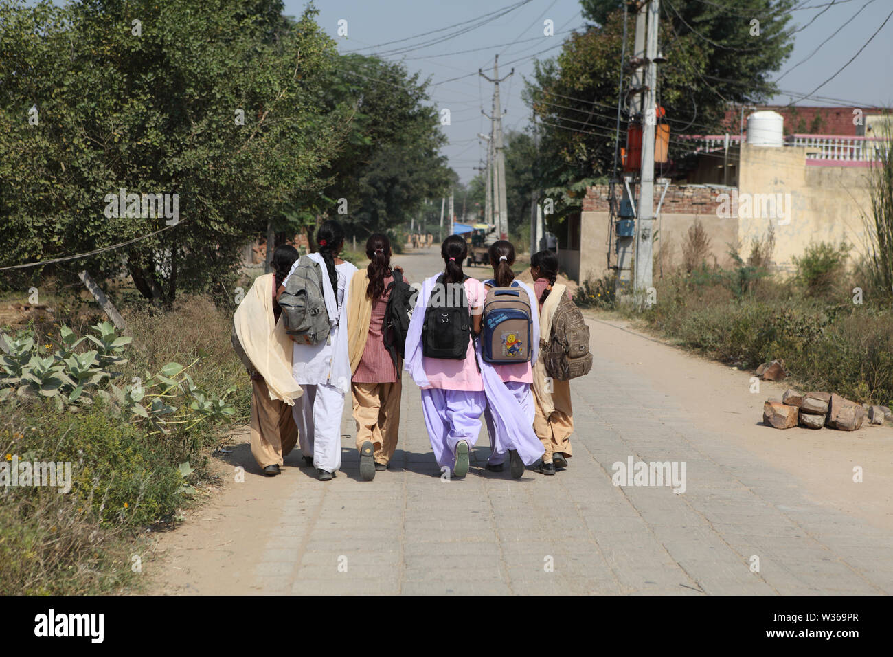 Rear view of schoolgirls walking to school Stock Photo