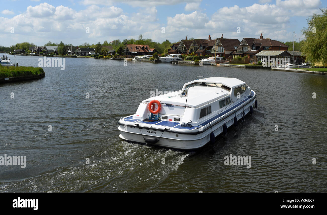 Broads Cruiser on the river Bure at Horning. Stock Photo