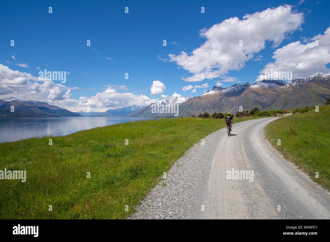 Dirt road through Farmland on shores of Lake Wakatipu near Queenstown, New Zealand for part of the Station to Station cycle trail. Stock Photo