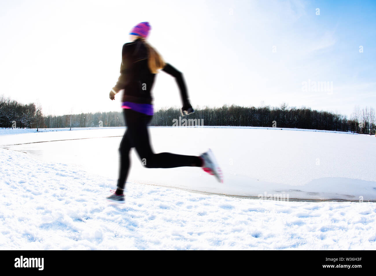 Blurred picture of young woman running at winter Stock Photo
