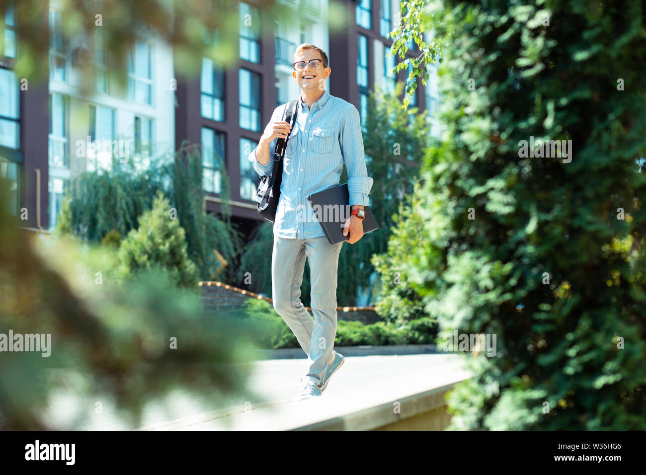 Software developer smiling while walking to the office in the morning Stock Photo