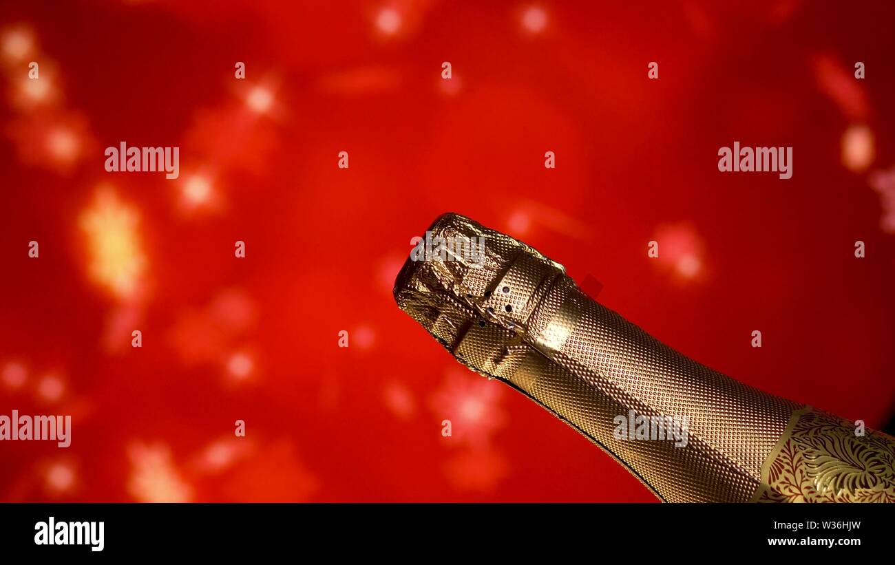 Champagne bottle. Holiday red blinking background. Party celebrating