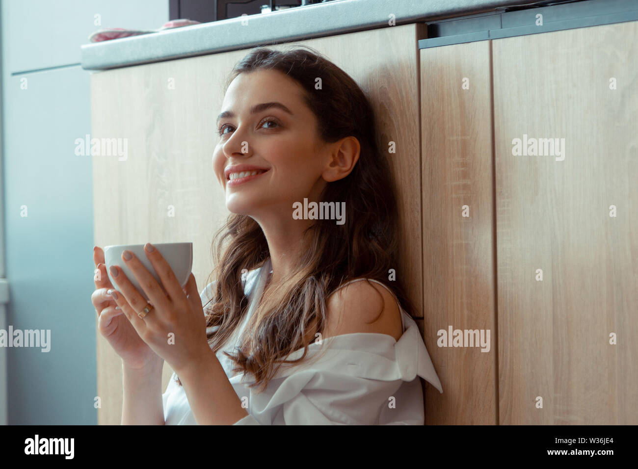Appealing dark-eyed woman drinking coffee in the morning Stock Photo