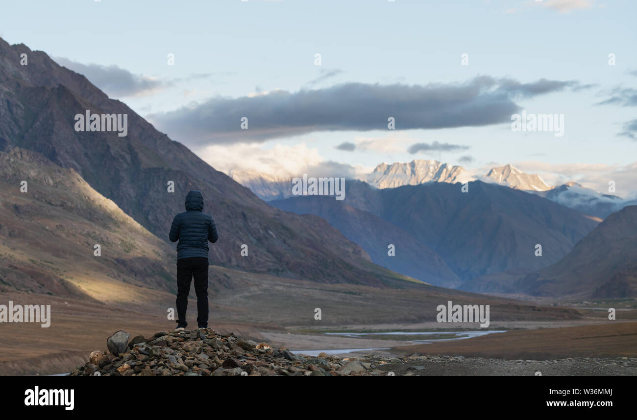 a man standing on the rock looking at mountains in the morning in India Stock Photo