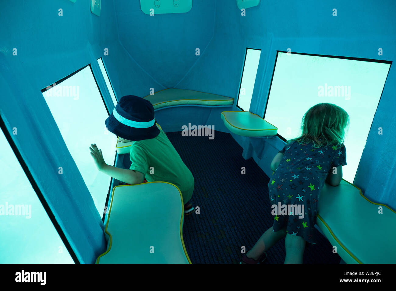 3 and 5 years old kids looking through the window of a glass bottom boat navigating through the Adriatic sea off the coast of Krk Island, Croatia Stock Photo