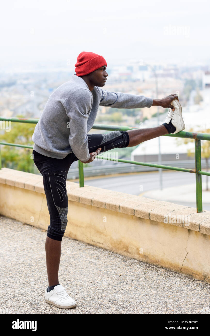 Black man doing stretching before running in urban background Stock Photo