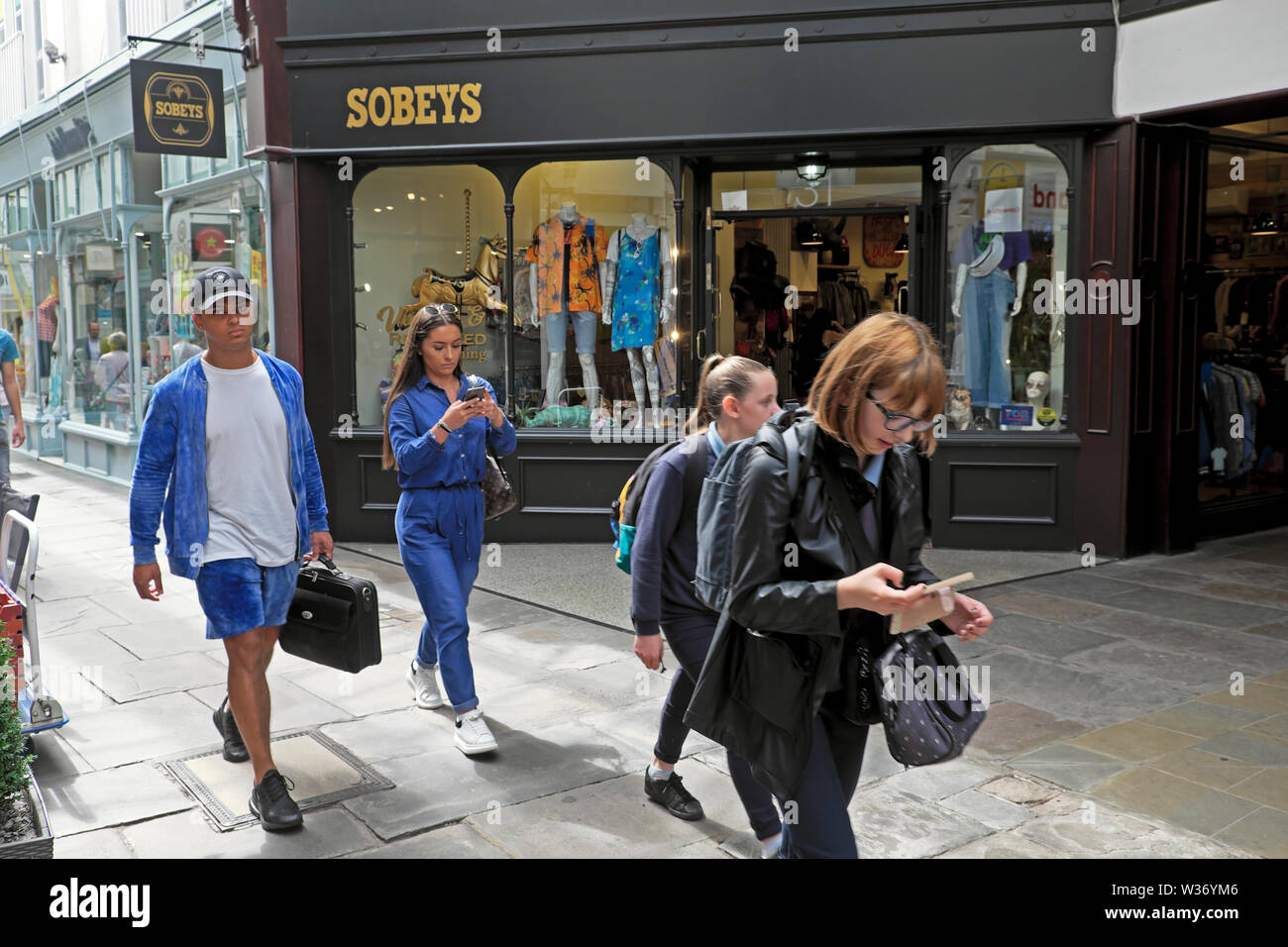 Exterior view of young people walking outside the entrance to Sobeys vintage clothing store in Royal Arcade Cardiff Wales UK  KATHY DEWITT Stock Photo