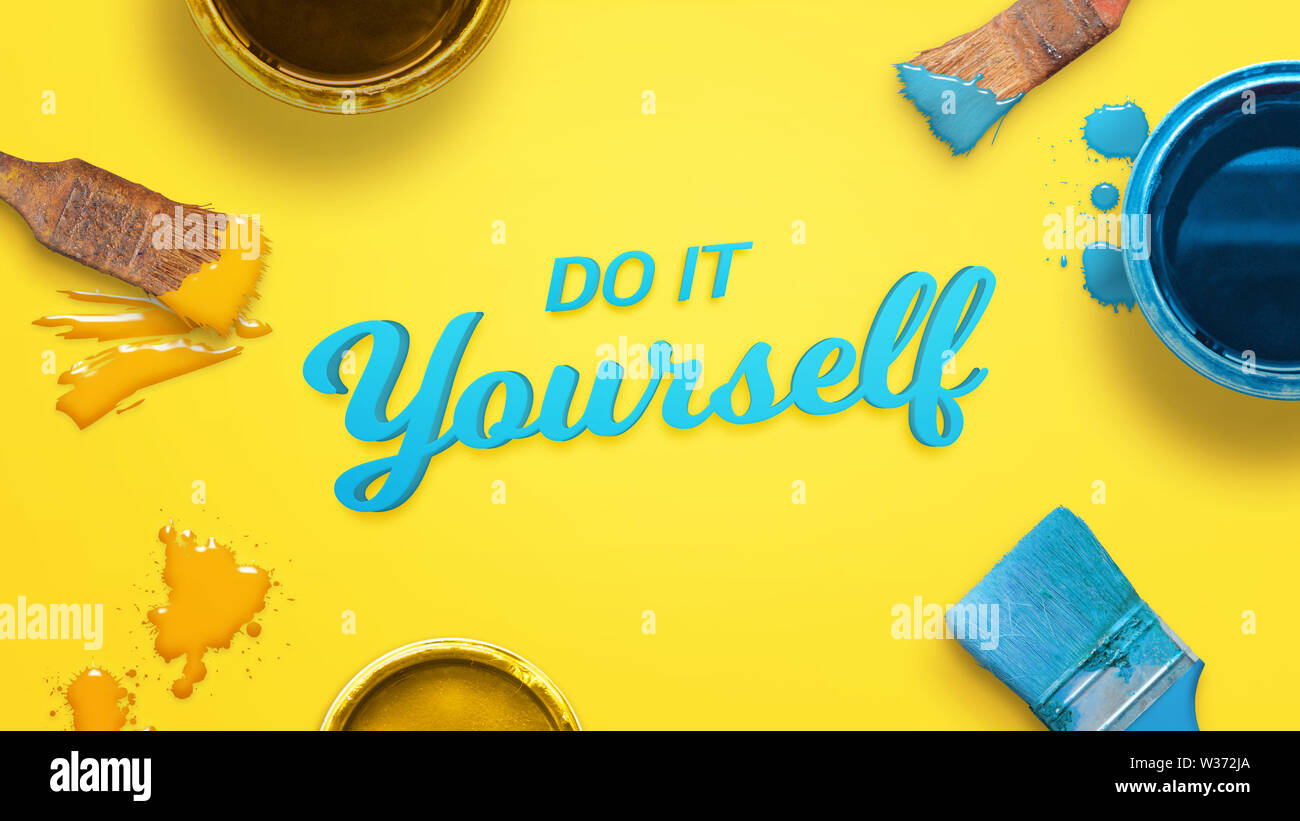 Do it yourself text surrounded with color brushes and boxes and a few drops of color on yellow surface. Stock Photo
