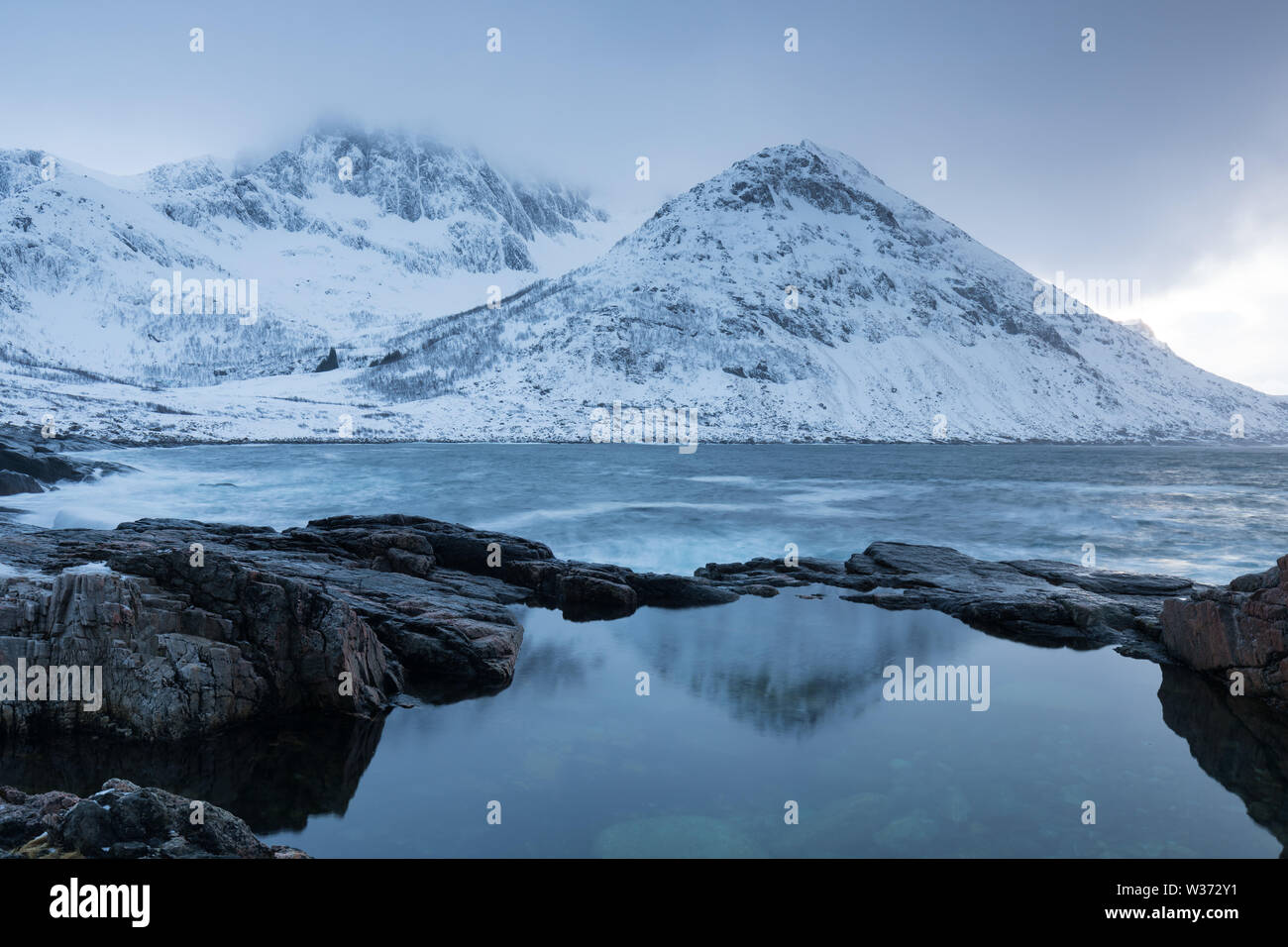 Winter view on Senja island. Cloudy dusk or night in Mountains And Fjords, Winter Landscape, fishing village, Norway Beautiful christmas time, Tromso Stock Photo