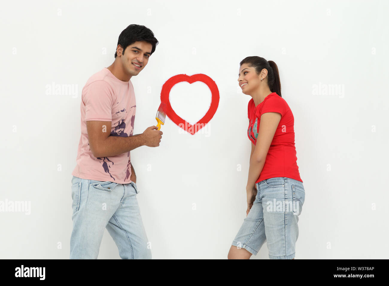 Couple painting heart on a wall Stock Photo