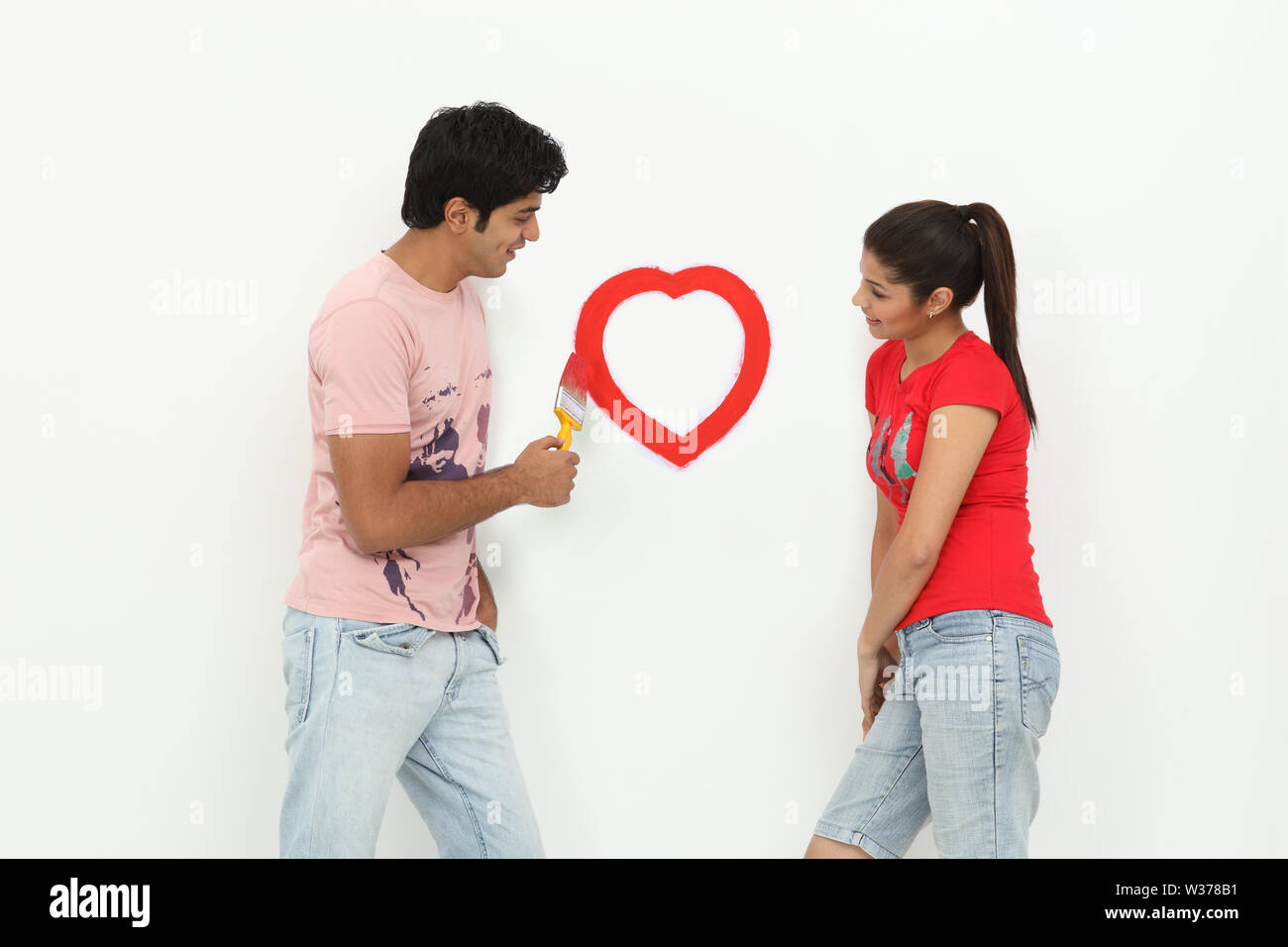 Couple painting heart on a wall Stock Photo