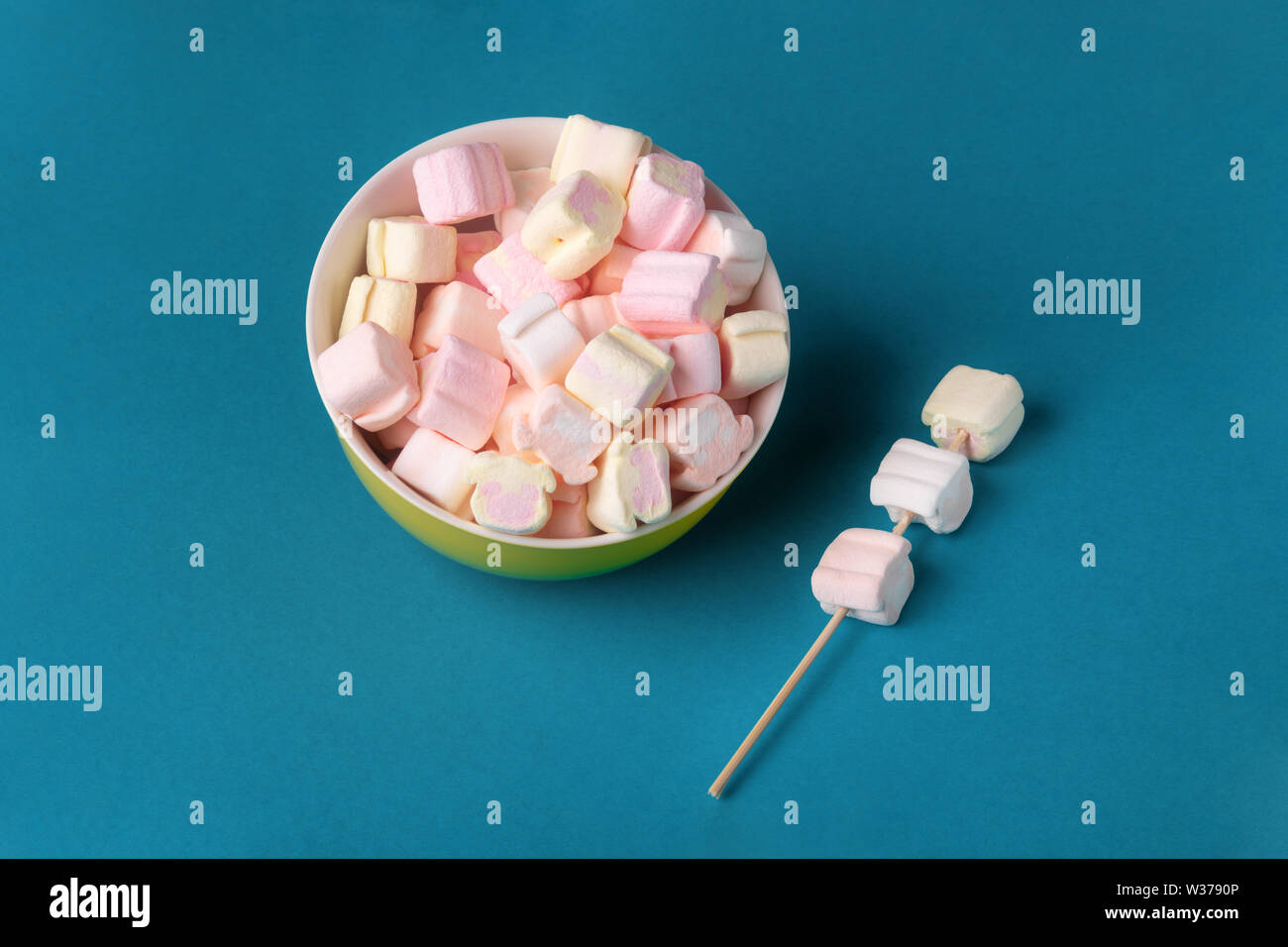 colorful marshmallows in plate on blue background Stock Photo