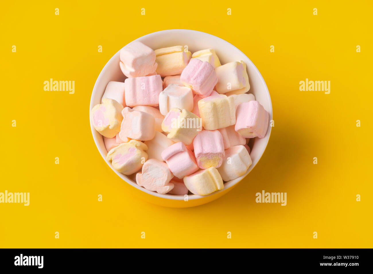 colorful marshmallows in plate on yellow background Stock Photo