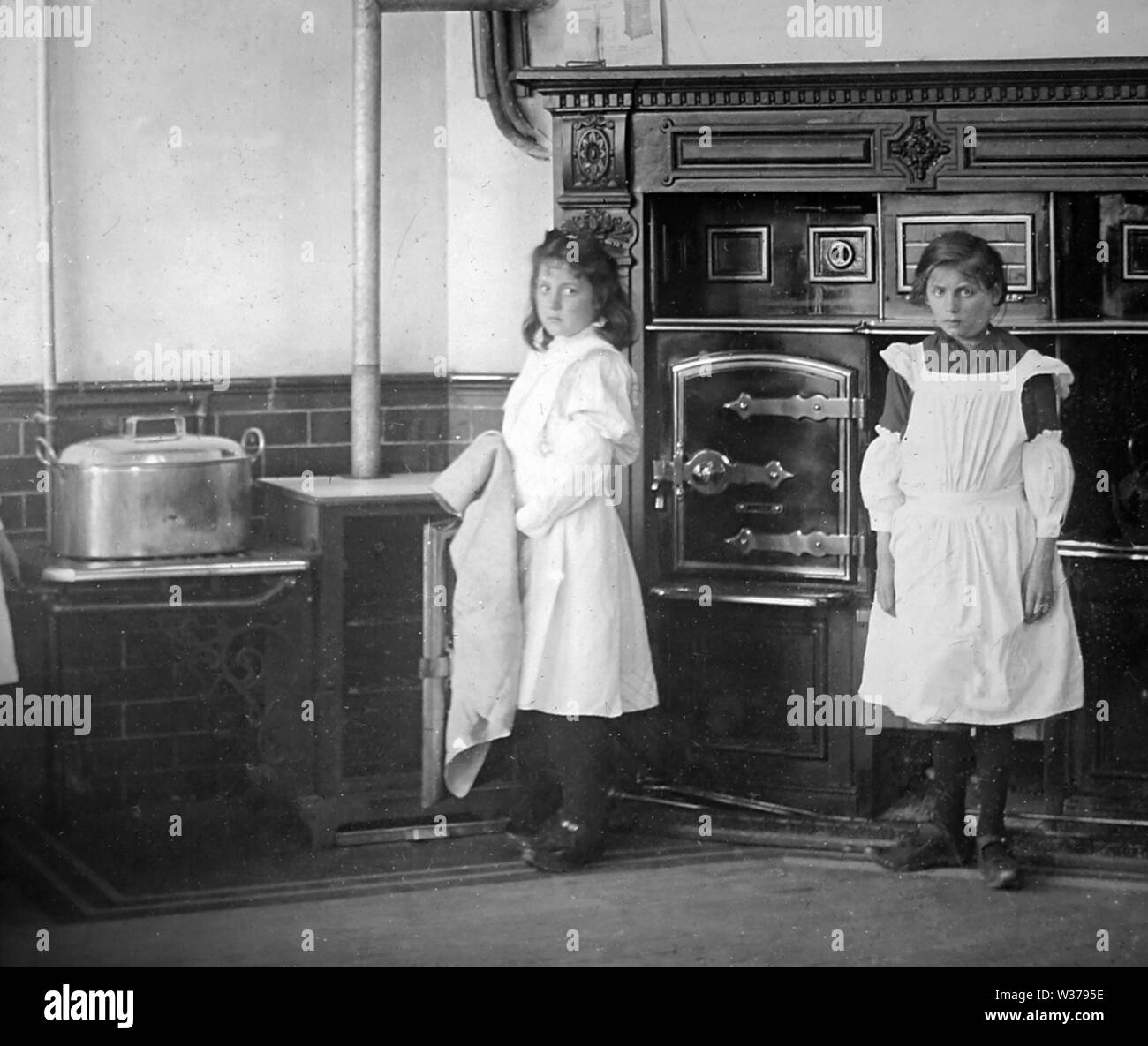 Domestic servants in a kitchen Stock Photo
