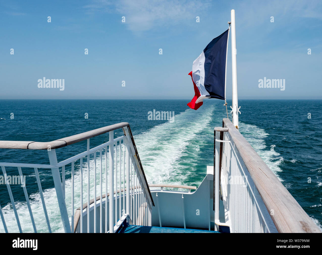 French Flag blowing in the wind on a ferry bound for the Port of Caen, Ouistreham, Normandy, France. Stock Photo