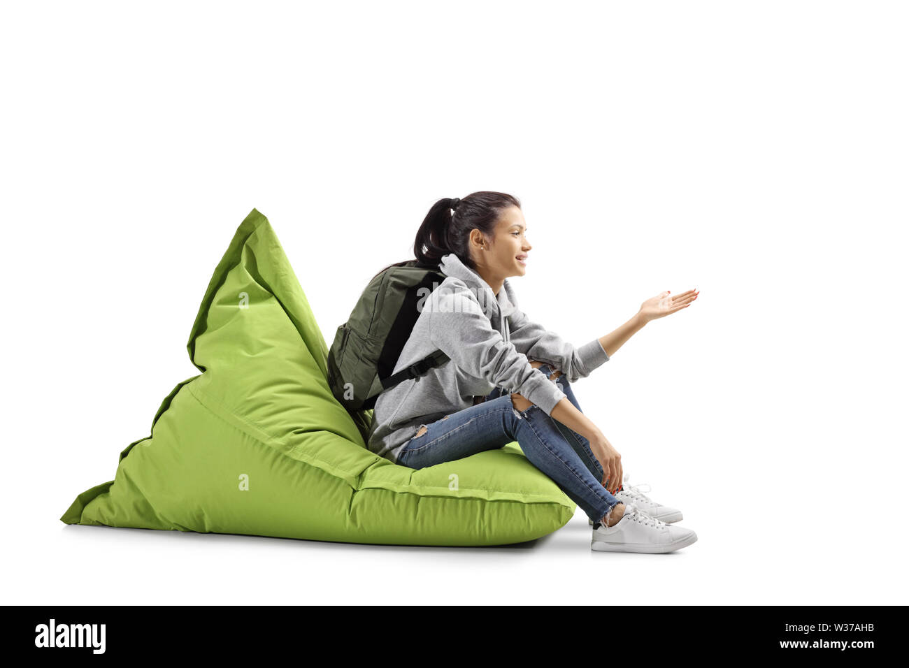 Female student sitting on a green bean bag and gesturing with hand isolated  on white background Stock Photo - Alamy
