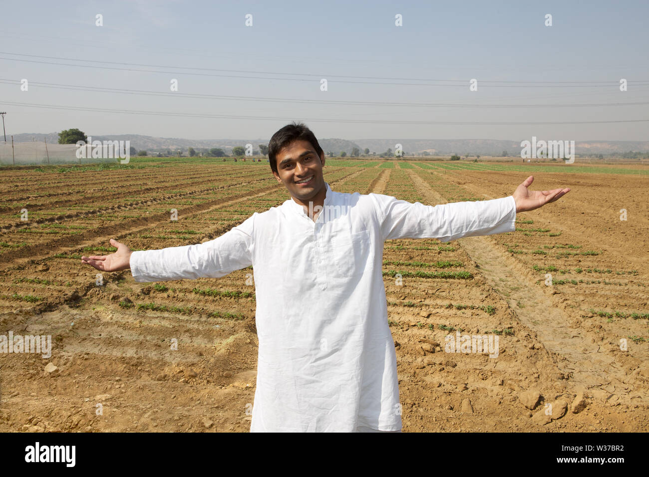 Portrait of a farmer showing his field Stock Photo - Alamy