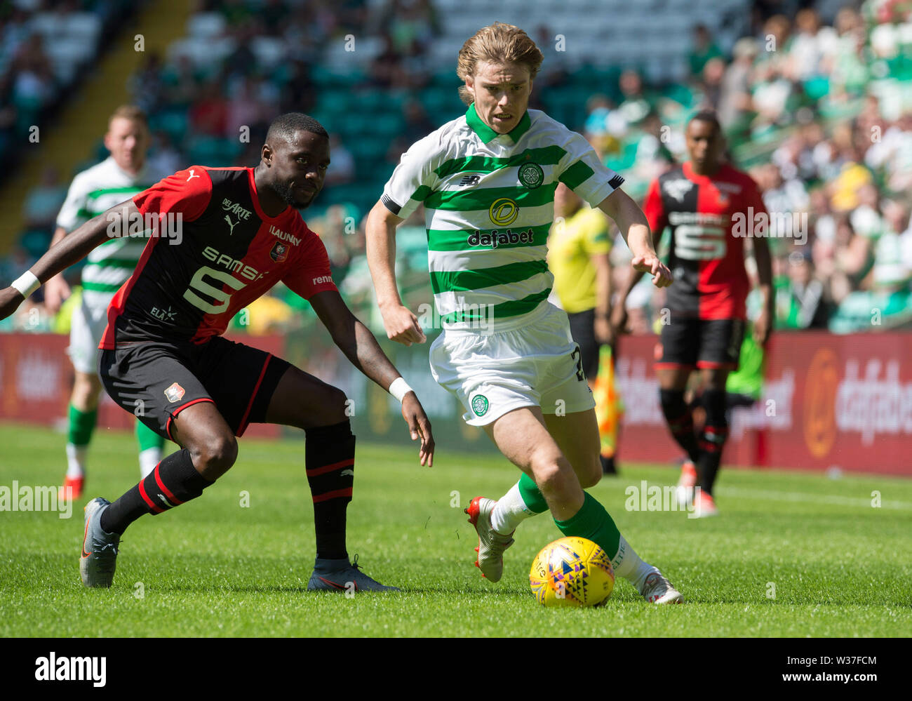 Celtic's Luca Connell in action and Stade Rennais Armand Lauriente during  the pre-season friendly match at Celtic Park, Glasgow Stock Photo - Alamy
