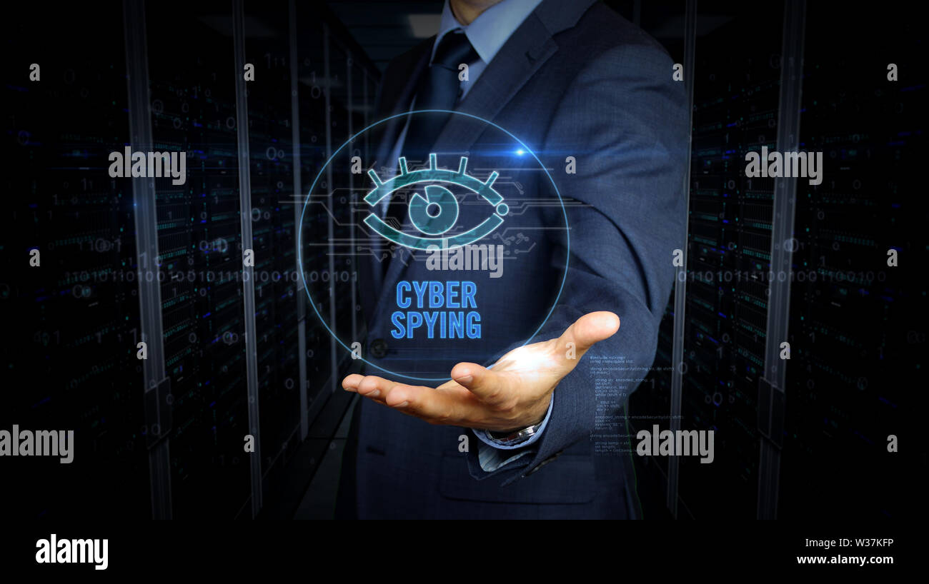 A businessman in a suit and screen with cyber eye hologram. Man using hand on virtual display interface. Digital surveillance, spying, hacking and vio Stock Photo