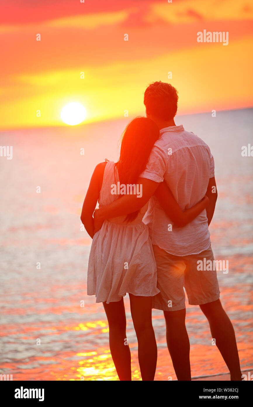 Honeymoon couple romantic in love at beach sunset. Newlywed happy ...