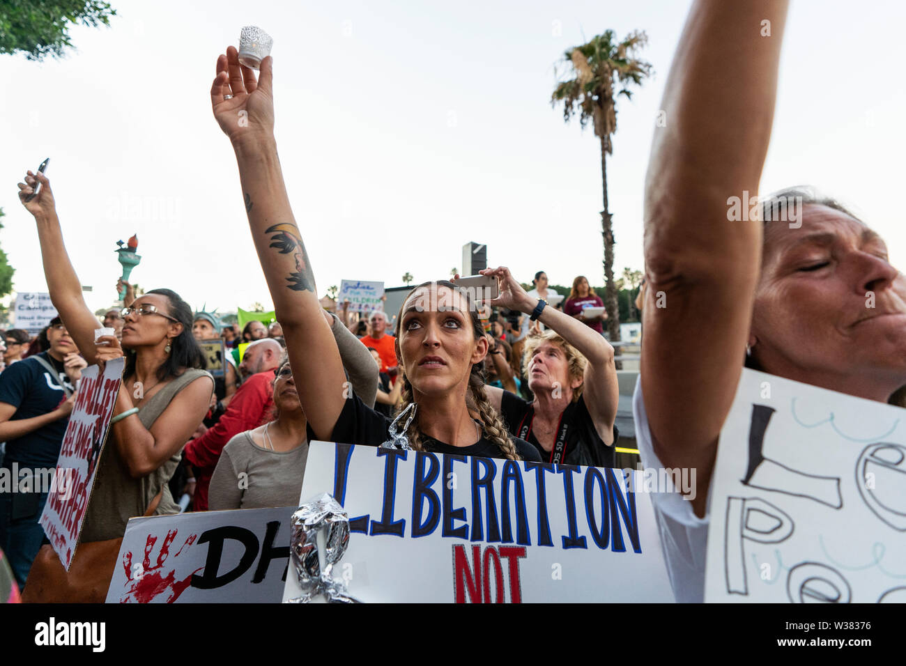 People protest against ICE raids and migrant detention camps during a vigil outside an Immigration and Customs Enforcement detention center in Los Angeles. Organizers called on the Trump administration to close all migrant detention camps. Similar Lights for Liberty rallies and vigils took place across the nation. Stock Photo