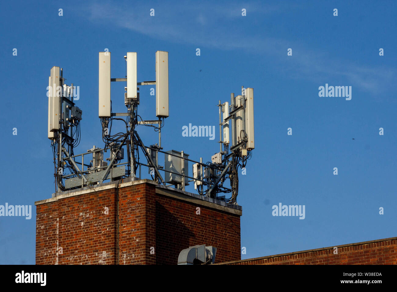 WIfi or cell phone antenna seen on the top of a re brick building in