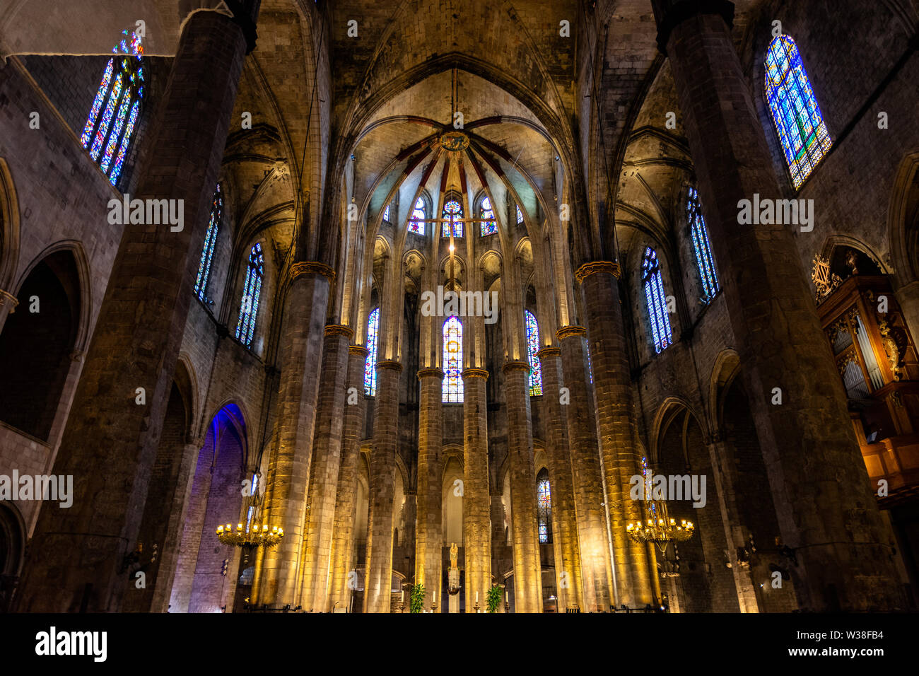 Interior of Santa Maria del Mar Basilica in typical Catalan Gothic style with pointed arches, high columns and colourful windows. La Ribera, Barcelona Stock Photo
