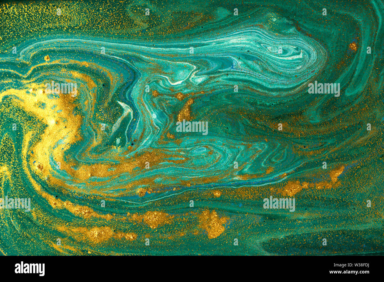 Liquid uneven green marbling pattern with golden glitter and glare of light Stock Photo