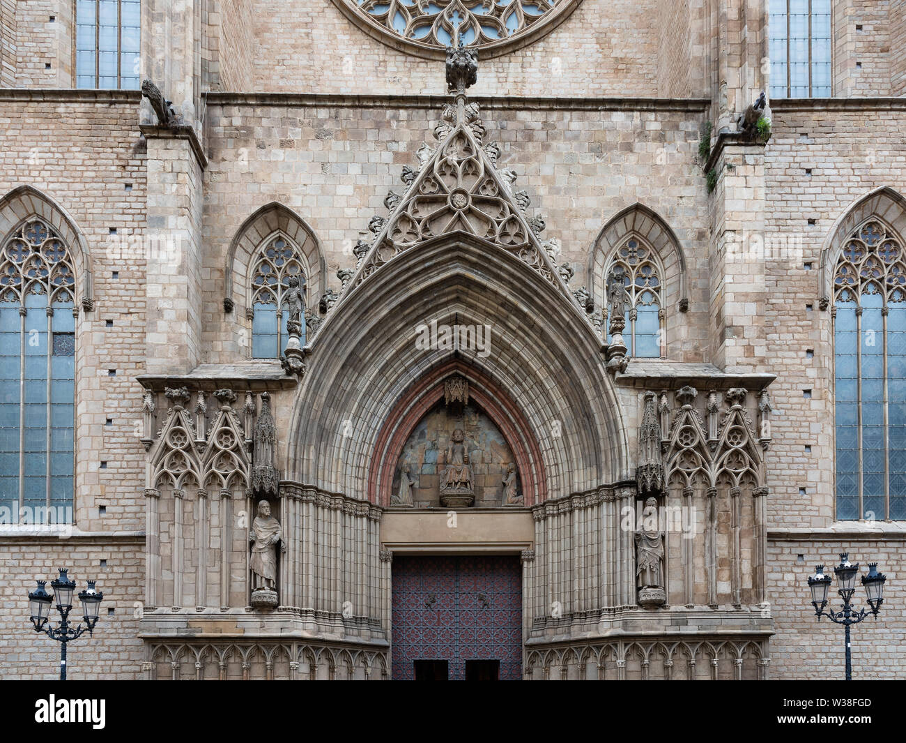 Detail of the main entrance of Basilica Santa Maria del Mar in typical Catalan Gothic with pointed arch and bronze main door. In the main door two bas Stock Photo