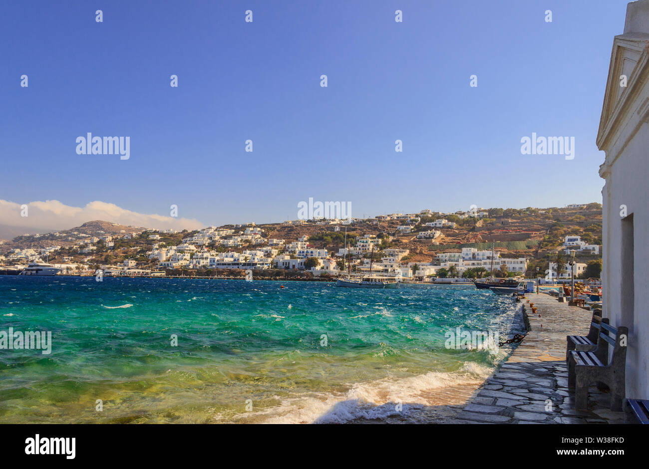 Whitewashed and blue domed Agios Nikolaos church in Mykonos, Greece, Europe. Panoramic view of old town and harbor: traditional greek village. Stock Photo