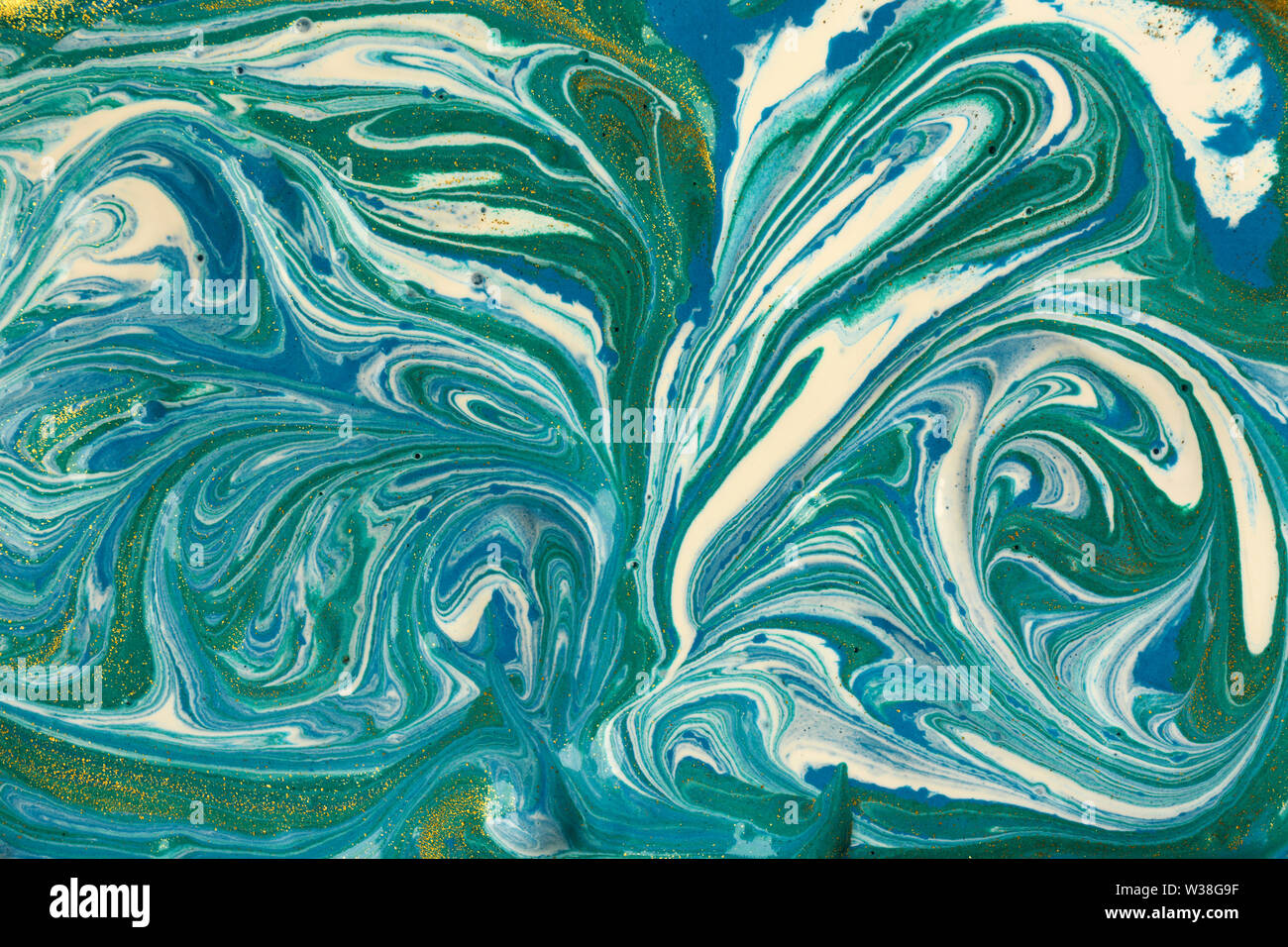 Liquid uneven blue and green marbling pattern with glare of light. Stock Photo