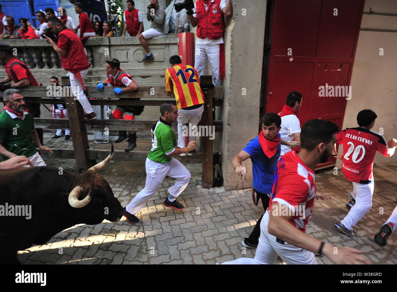 People run from the bulls during the festivities.San Fermín festivities celebrate the confinement of the bulls of the cattle ranch. The Palmosilla (run of the bulls), was settled with no one injured by a bull horn and the morning hours passed with the visit of the big heads to the house of Misericordia making a fun morning among the elderly. Stock Photo