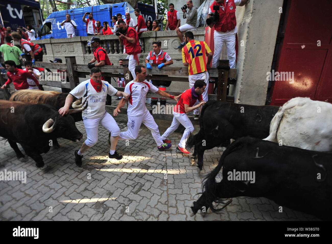 People run from the bulls during the festivities.San Fermín festivities celebrate the confinement of the bulls of the cattle ranch. The Palmosilla (run of the bulls), was settled with no one injured by a bull horn and the morning hours passed with the visit of the big heads to the house of Misericordia making a fun morning among the elderly. Stock Photo