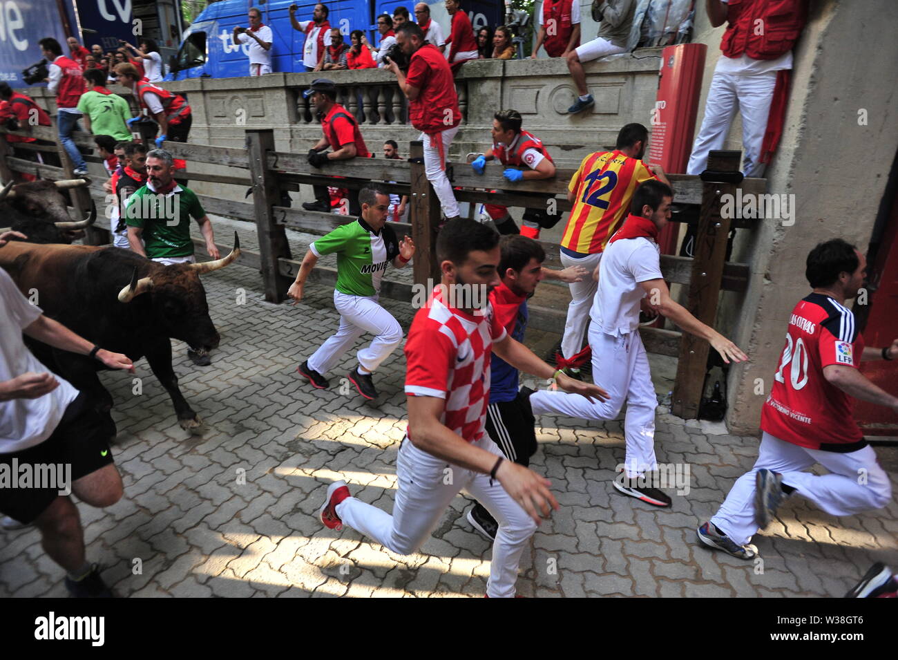 People run from the bulls during the festivities.San Fermín festivities celebrate the confinement of the bulls of the cattle ranch. The Palmosilla (run of the bulls), was settled with no one injured by a bull horn and the morning hours passed with the visit of the big heads to the house of Misericordia making a fun morning among the elderly. Stock Photo