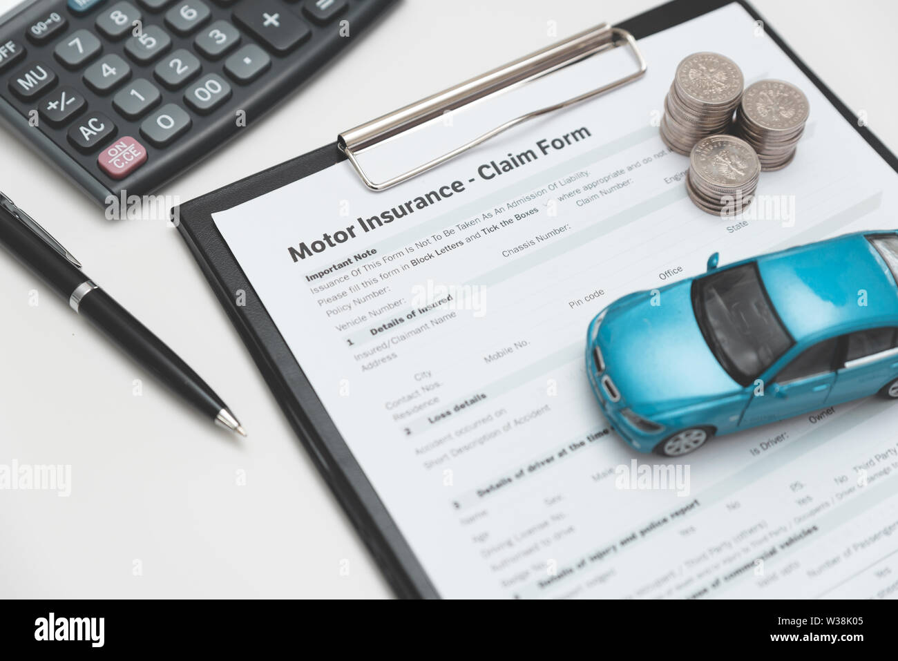 Motor or car insurance claim form with coin stack, calculator and car model. Stock Photo